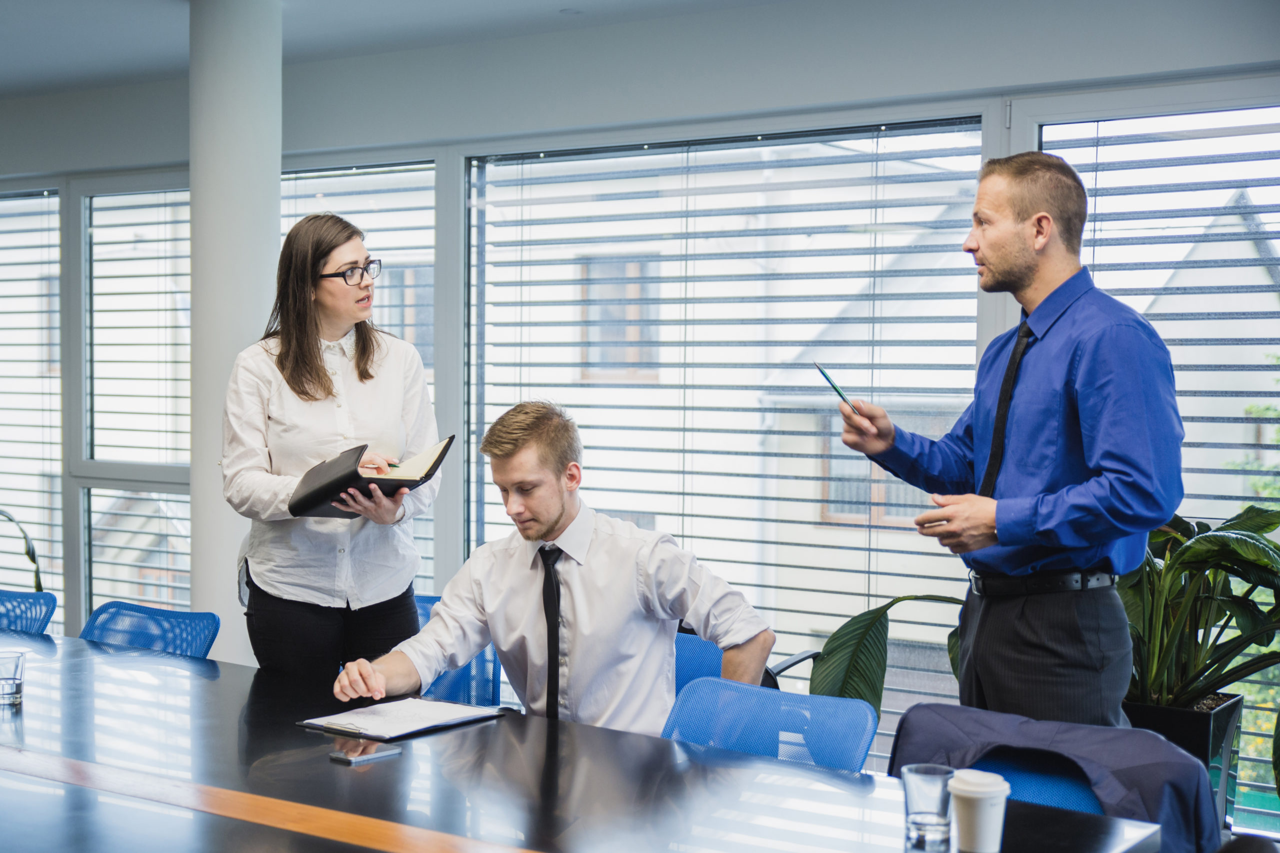 man-talking-coworkers-office